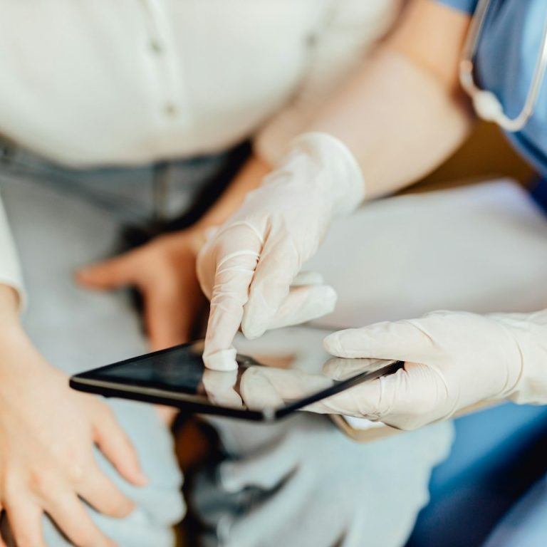 A healthcare provider at Vista Community Clinic assisting a patient with digital records on a tablet, representing access to care and review